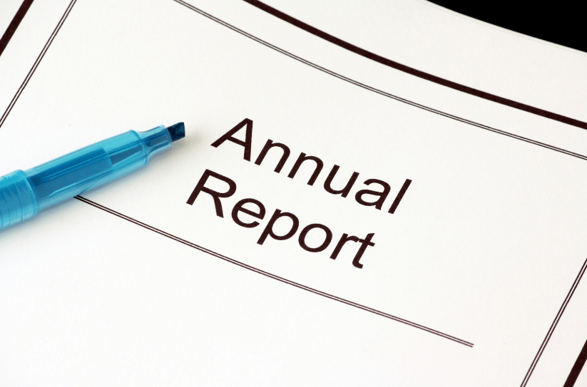 The words ‘annual report’ surrounded by a pen, as someone researches what annual reports and returns a charity needs to make.